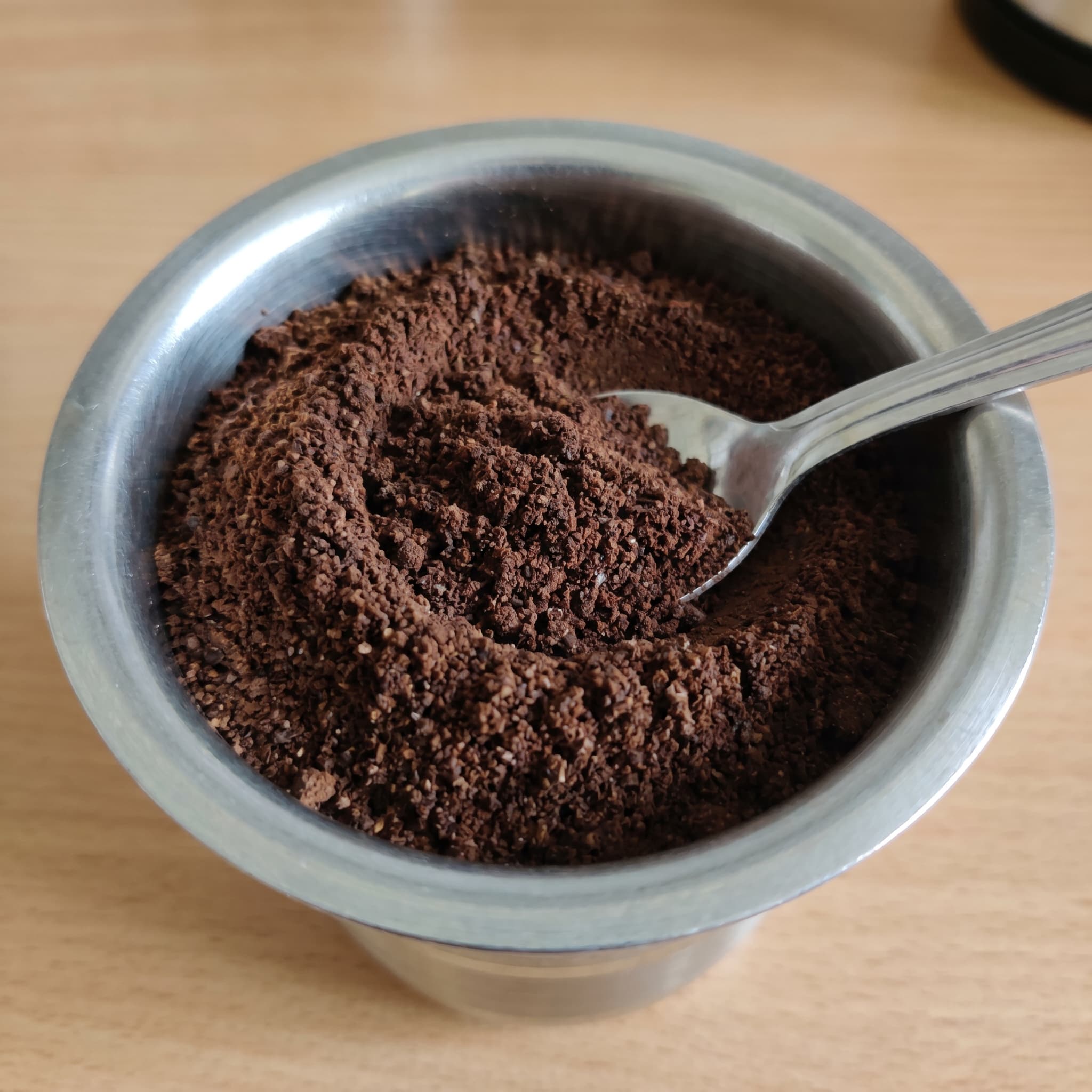 South Indian filter coffee being poured into a traditional davara tumbler